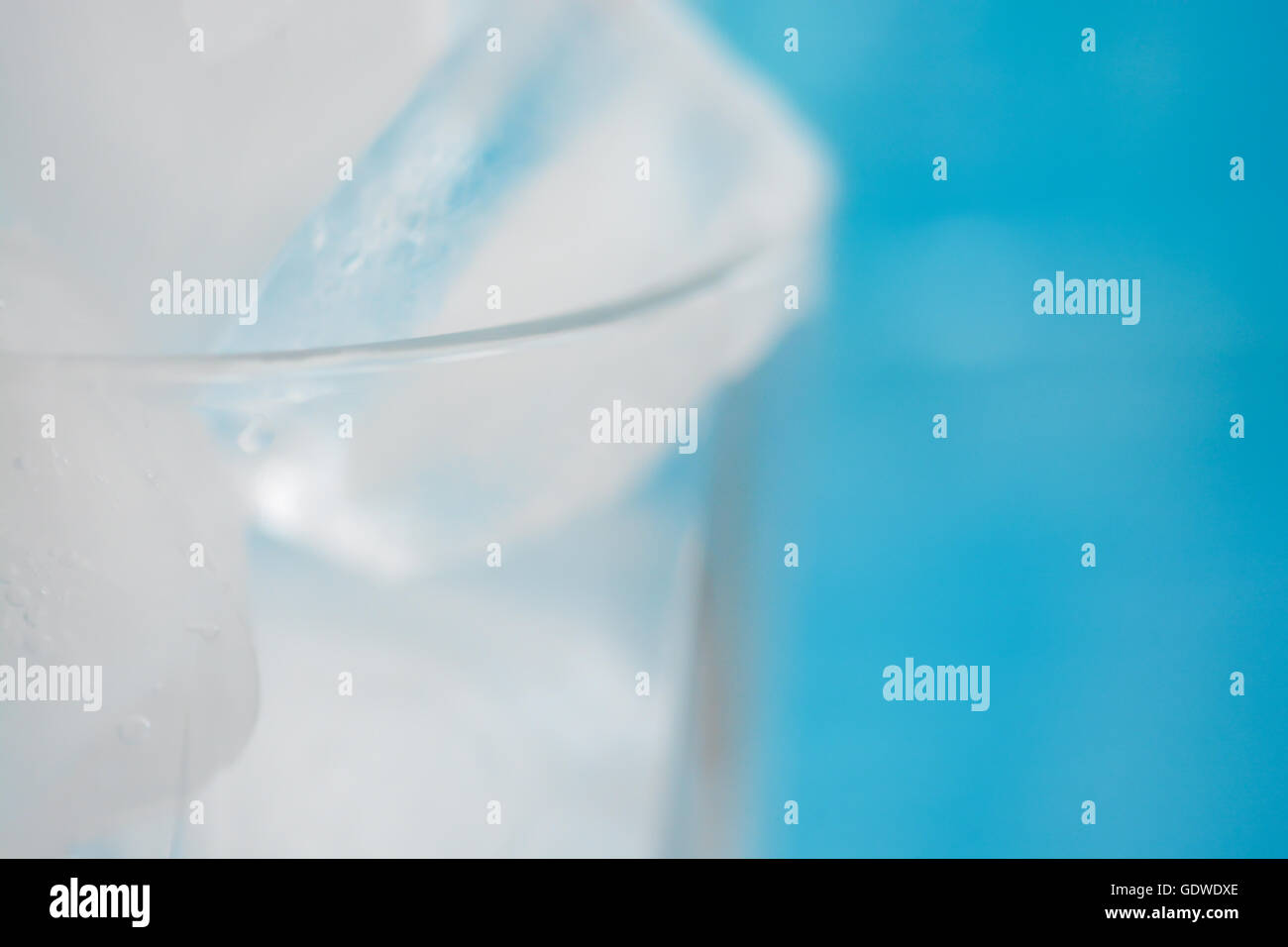 Ice cubes in a glass on blue background Stock Photo - Alamy