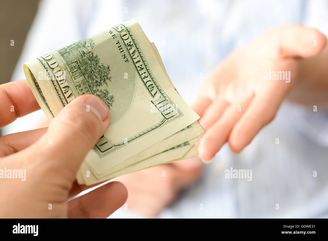 Give money to someone as bribe to suggest a corrupt system Stock Photo