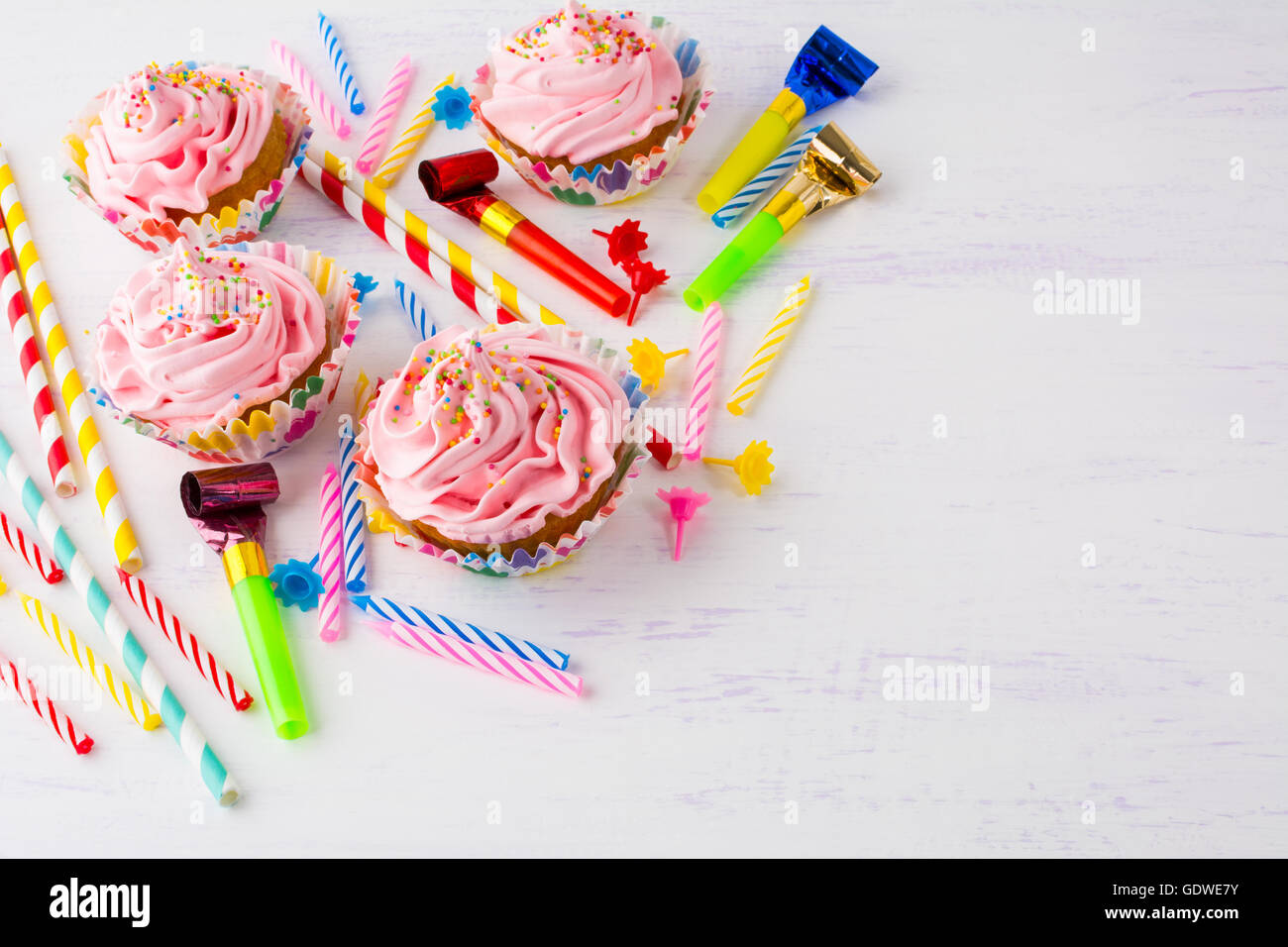 Birthday background with pink cupcakes and birthday candles. Homemade cupcakes with whipped cream. Holiday party background. Stock Photo