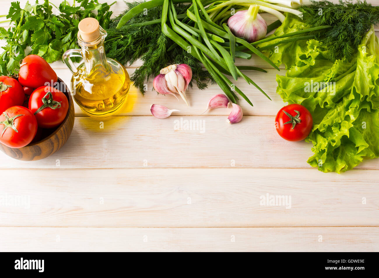 Tomato, olive oil and garlic on white wooden background. Healthy eating concept with fresh vegetables. Vegetarian  vegan food ba Stock Photo