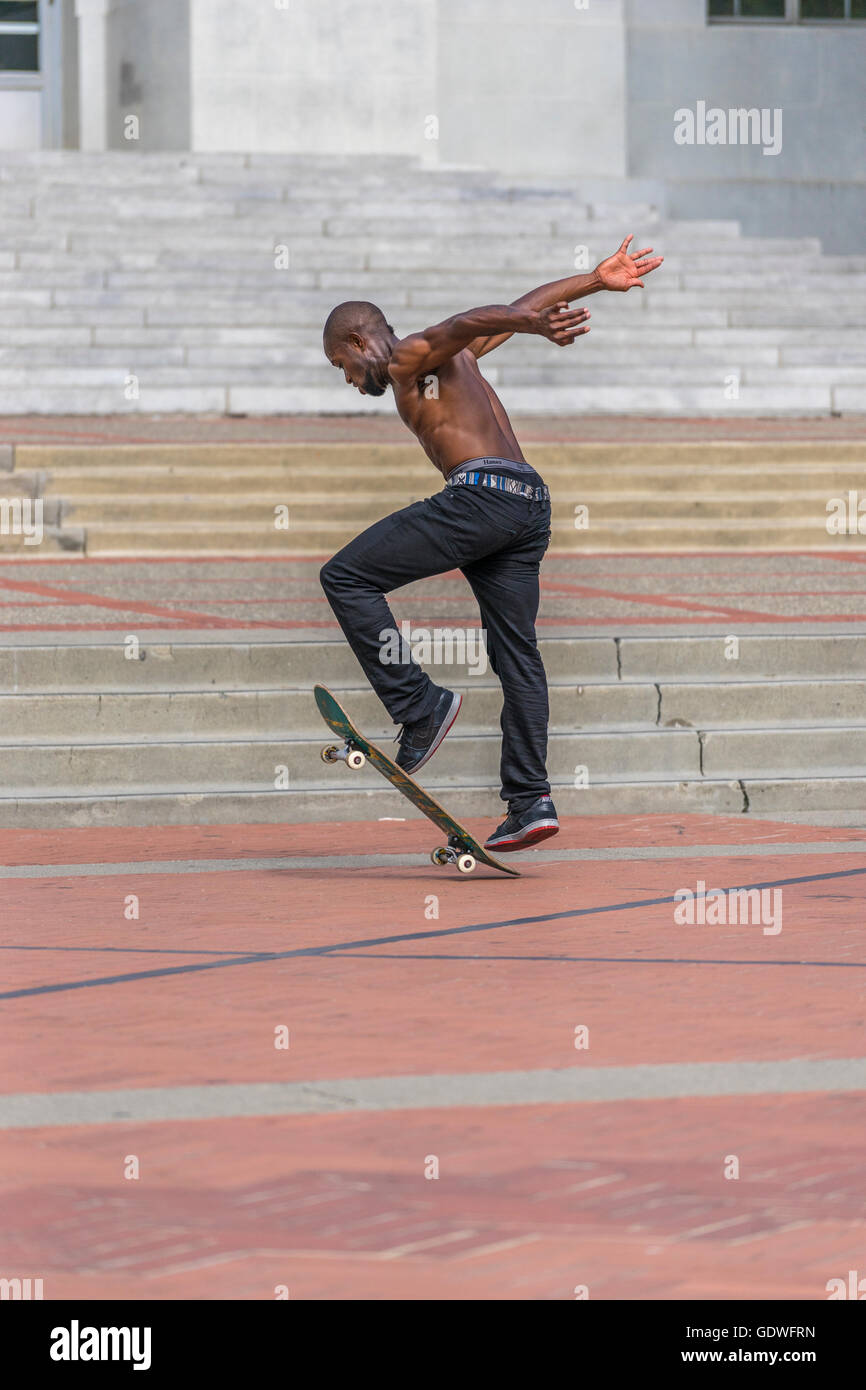 Man popping up his skateboard as he practices his kickflip trick Stock Photo
