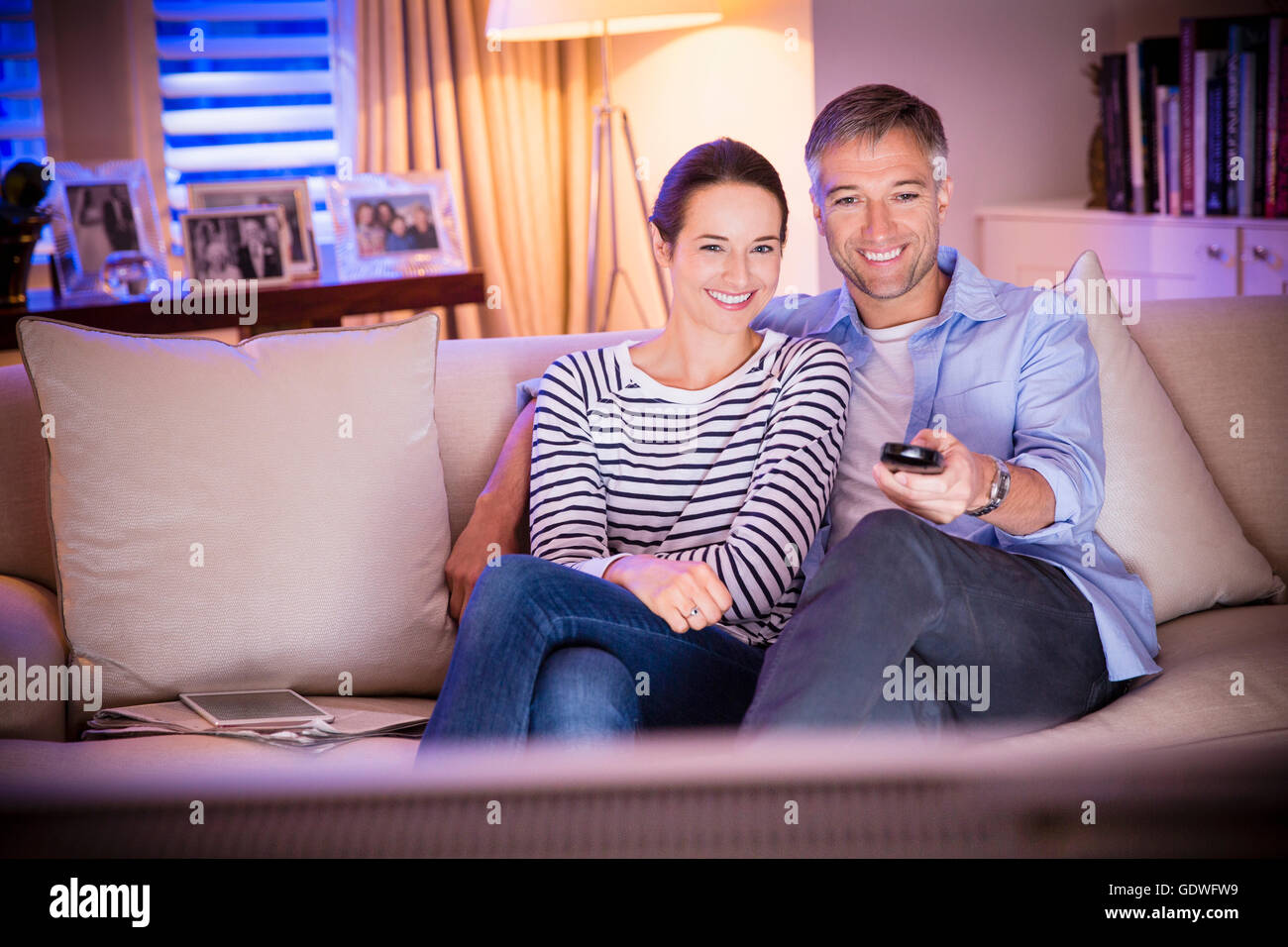 Smiling couple watching TV in living room Stock Photo