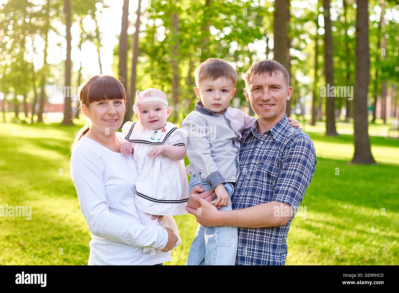 Happy young family with children walks in the summer park Stock Photo