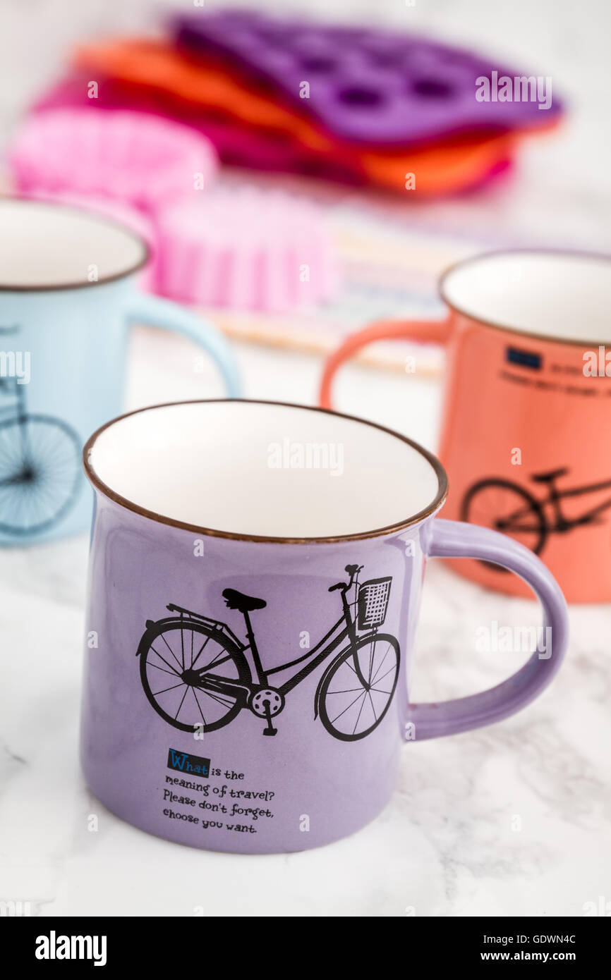 Colorful modern ceramic mugs with bicycle design on white marble