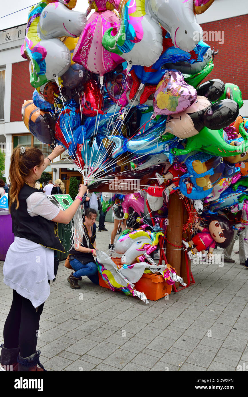 Woman holding helium filled balloons for sale, UK Stock Photo Alamy