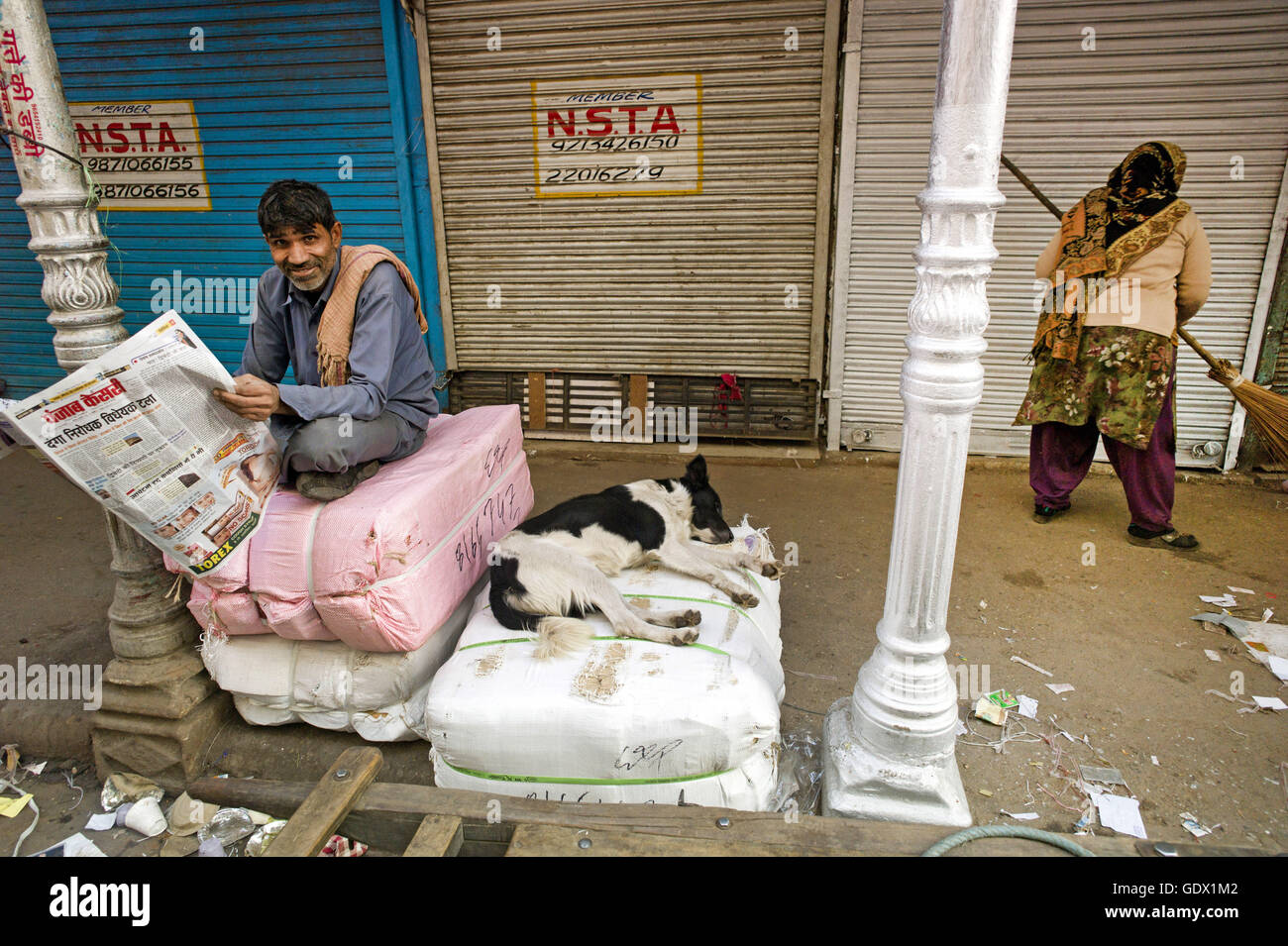 Man reads the newspapers on the street in New Delhi, India, 2014 Stock Photo