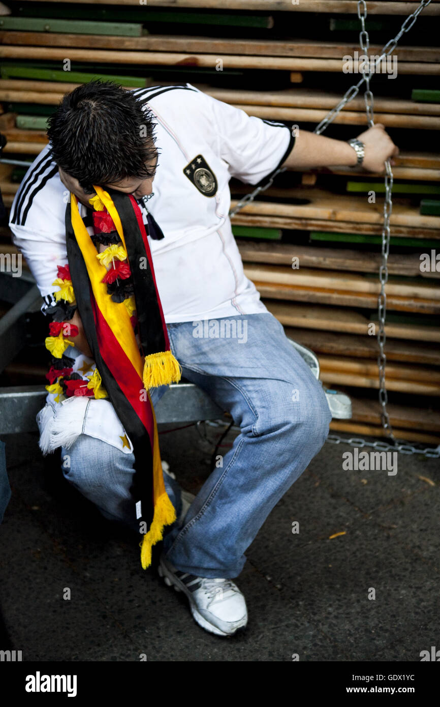 Drunk football fan sleeps on the German Fan Mile at the World Cup in Berlin, Germany, 2010 Stock Photo