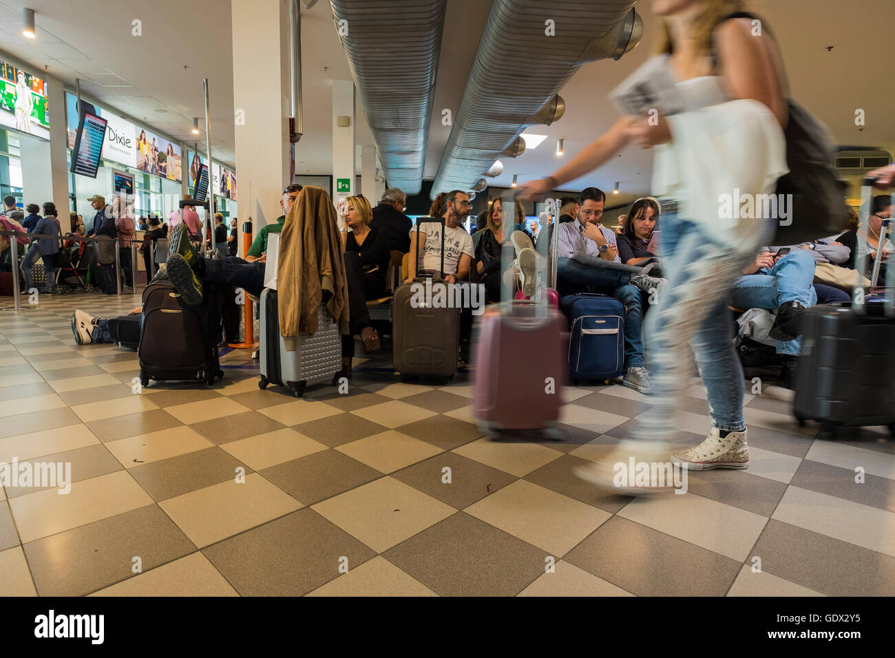 Passengers in departure lounge at Galileo Galilei airport waiting for their flight, Pisa, Tuscany, Italy Stock Photo