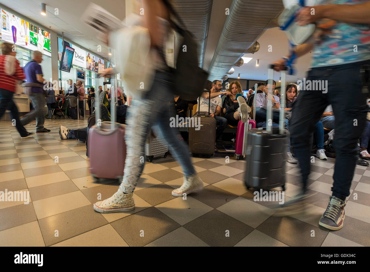 Passengers in departure lounge at Galileo Galilei airport waiting for their flight, Pisa, Tuscany, Italy Stock Photo
