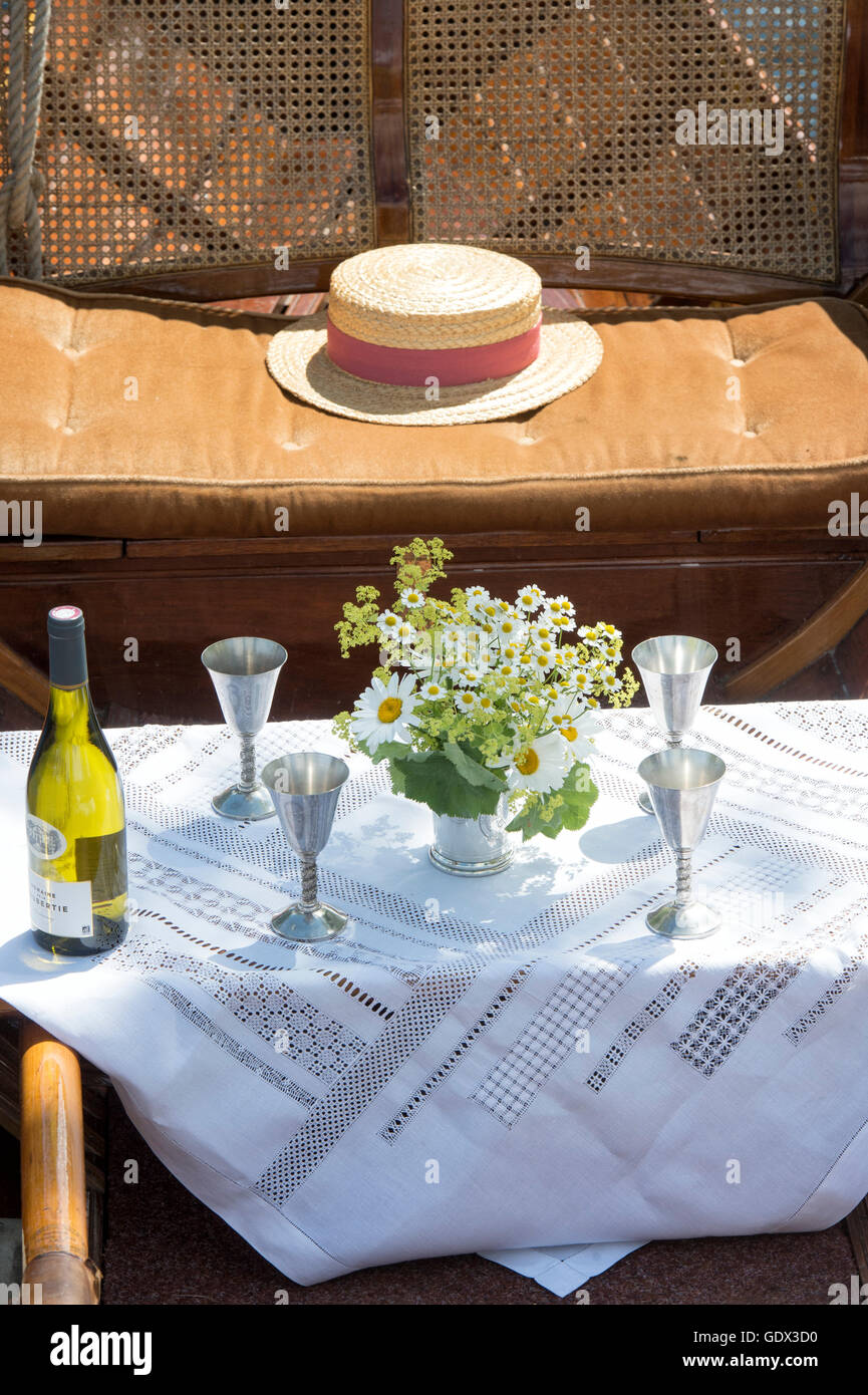 Wine goblets, flowers and boater in a wooden rowing boat at the Thames Traditional Boat Festival, Henley On Thames, Oxfordshire, England Stock Photo