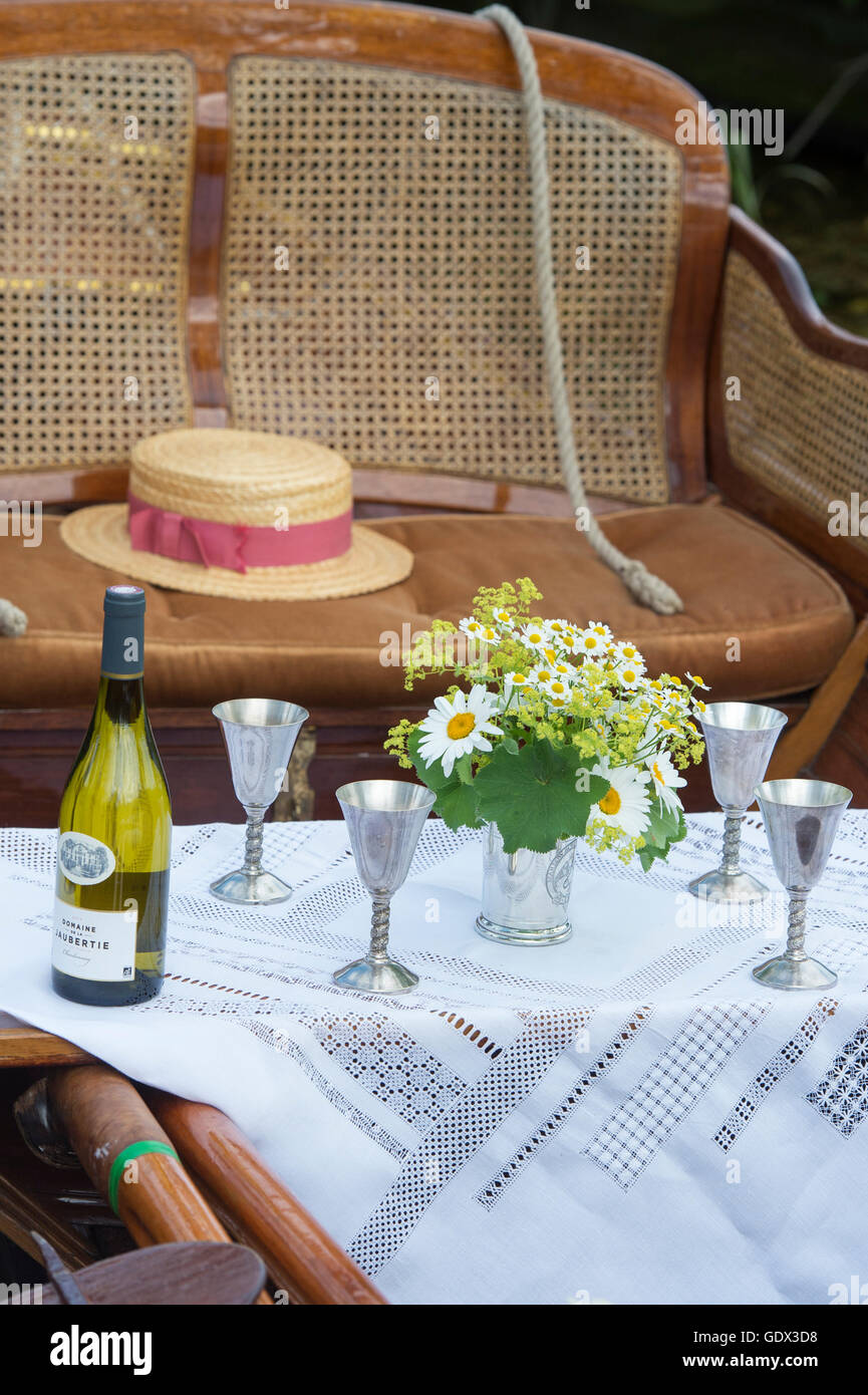 Wine goblets, flowers and boater in a wooden rowing boat at the Thames Traditional Boat Festival, Henley On Thames, Oxfordshire, England Stock Photo
