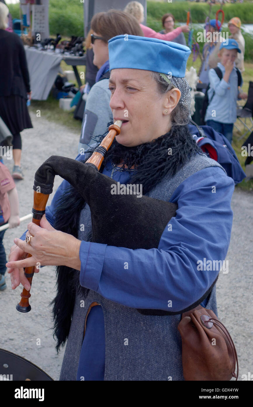 A woman plays old medieval Nordic (Swedish) bagpipe. Stock Photo