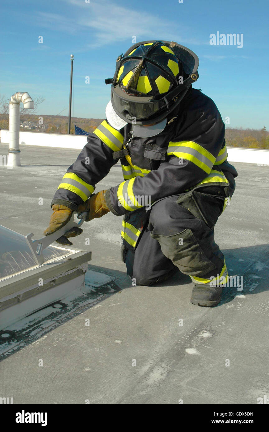 Firefighters Using A Rook Firefighter on a roof with a tool Stock Photo - Alamy