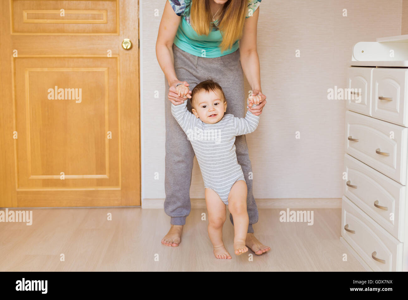 Cute smiling baby boy learning to walk Stock Photo