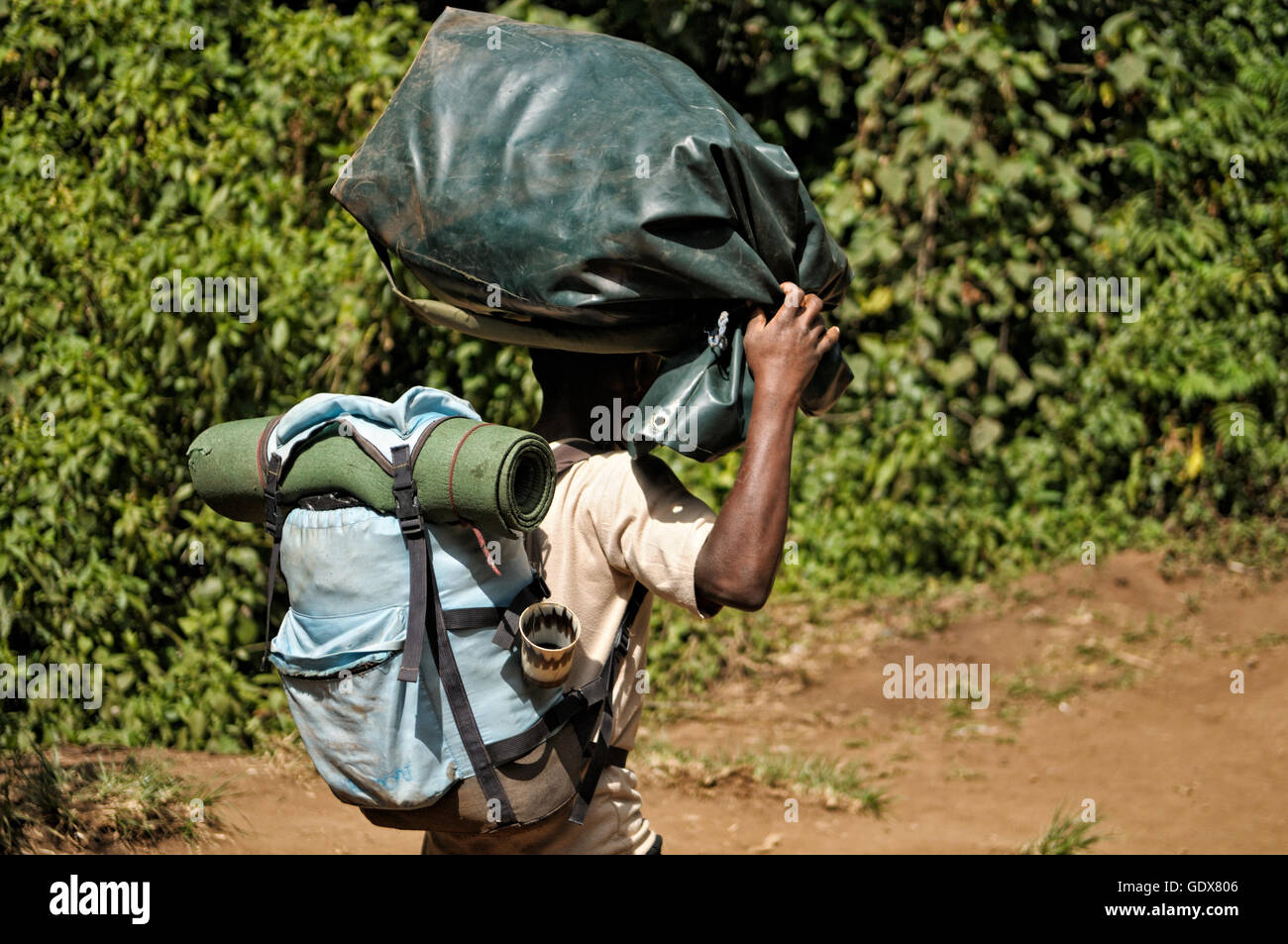 Porter carrying a backpack and another bag on his head, Mount Kilimanjaro National Park, Tanzania Stock Photo