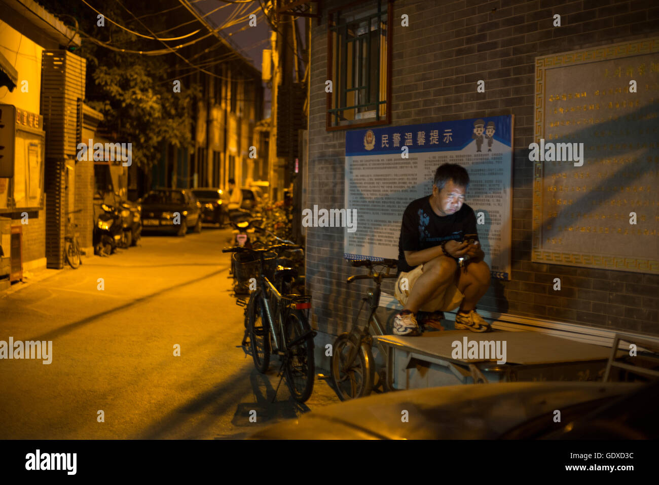 Man using smartphone and internet, in the Shitou hutong area, in Beijing, China. Stock Photo