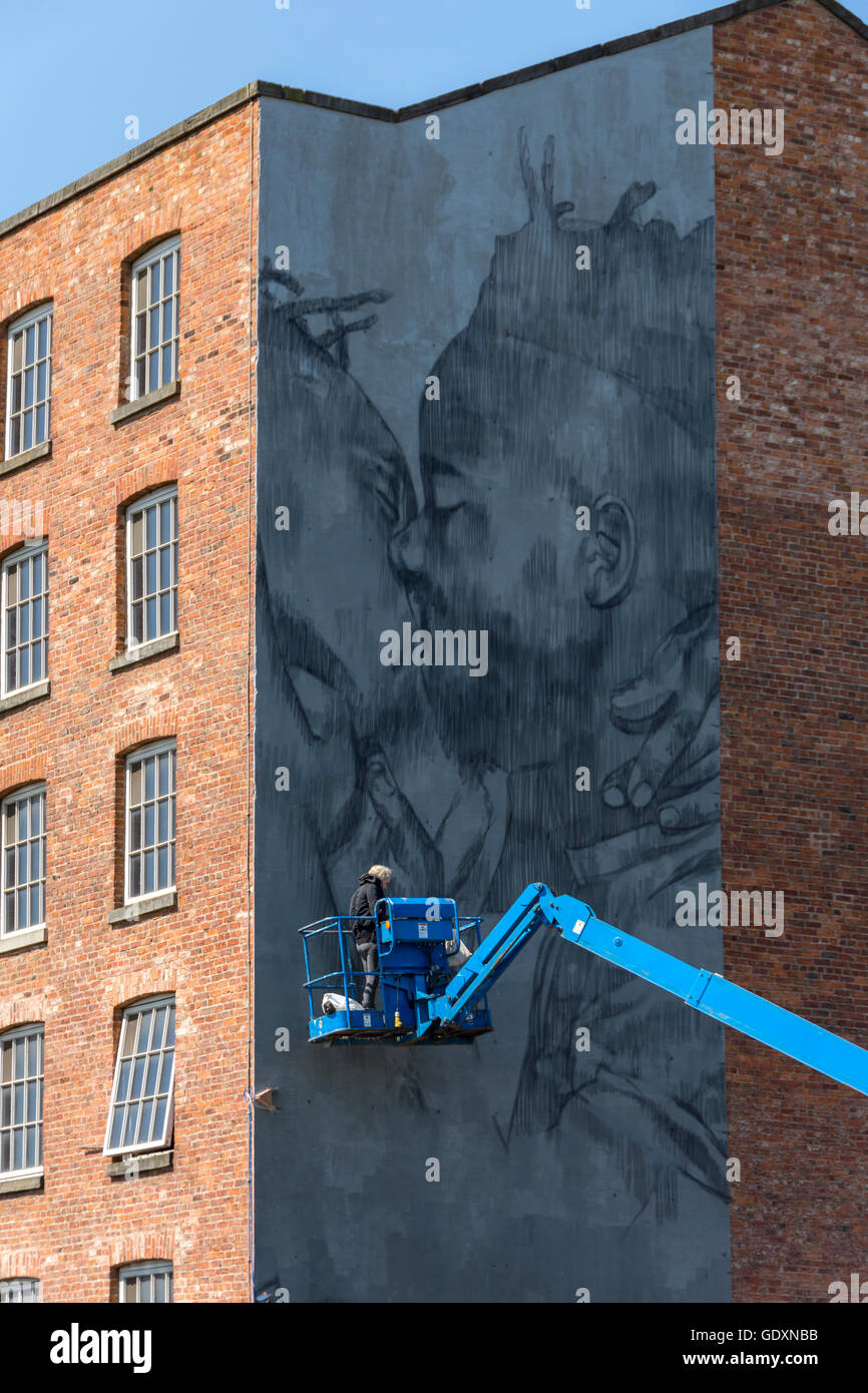 Street artist Faith47 at work on the mural '722-481 BC' on the side of Brownsfield Mill, Ancoats, Manchester, England, UK Stock Photo