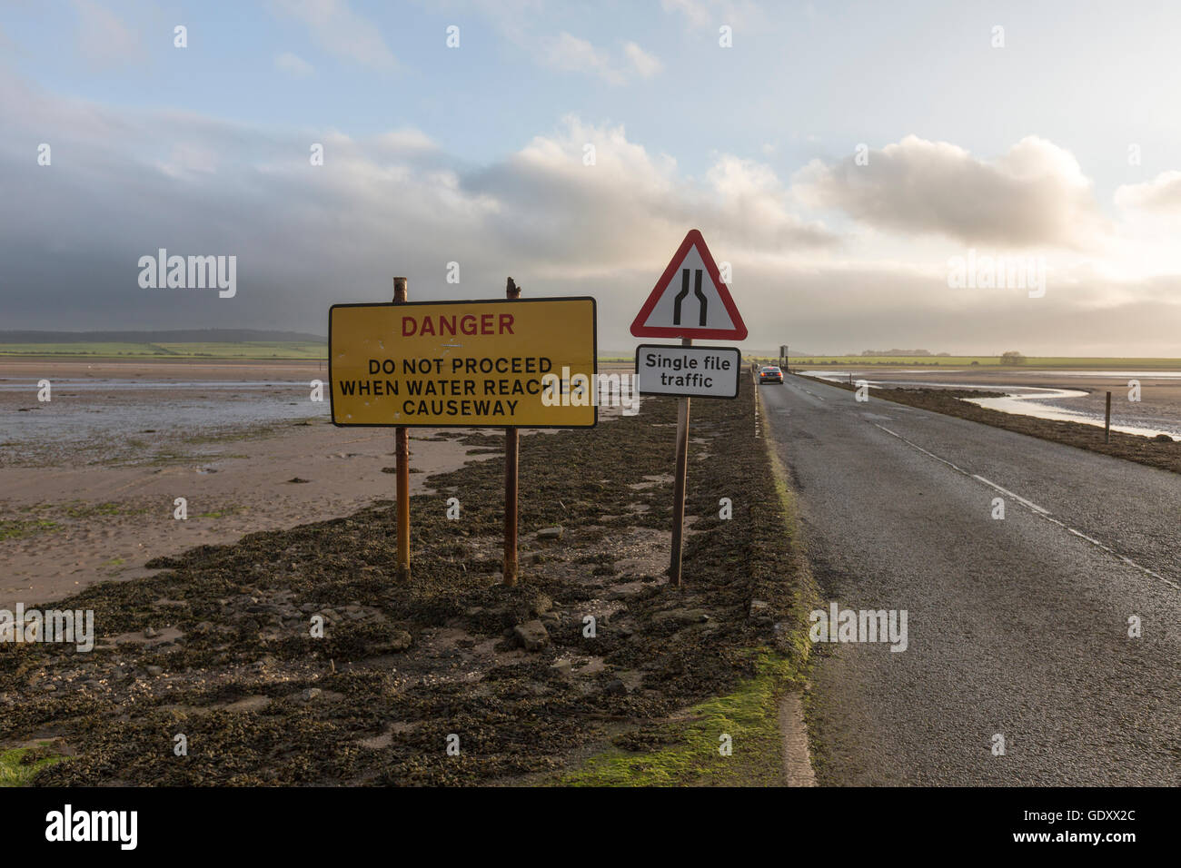 Signs of Danger in a causeway in low tide to The Holy Island of Lindisfarne, Northumberland, England, UK Stock Photo