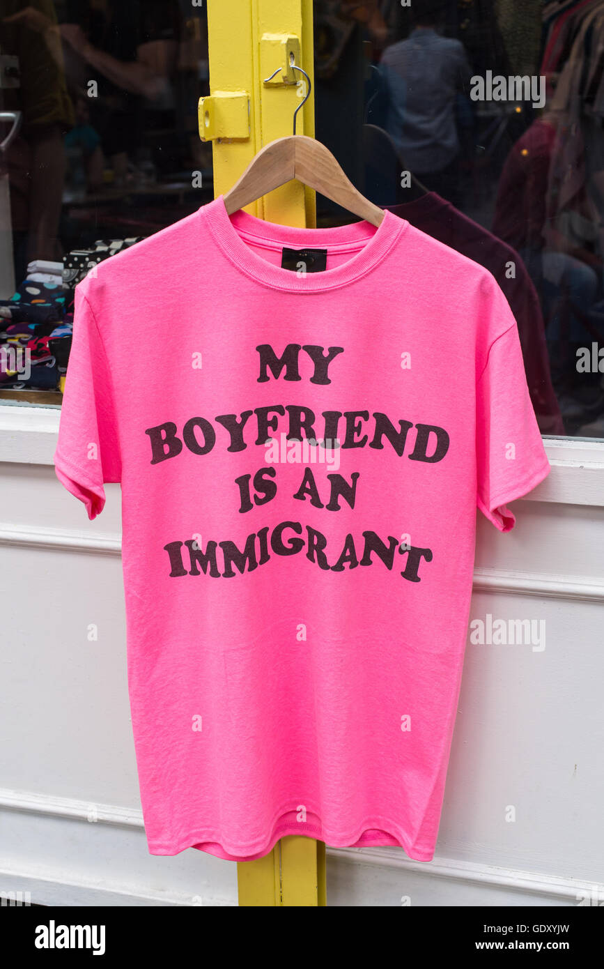 Bright pink T-shirt with the words My boyfriend is an immigrant written on it, hanging outside a shop Stock Photo