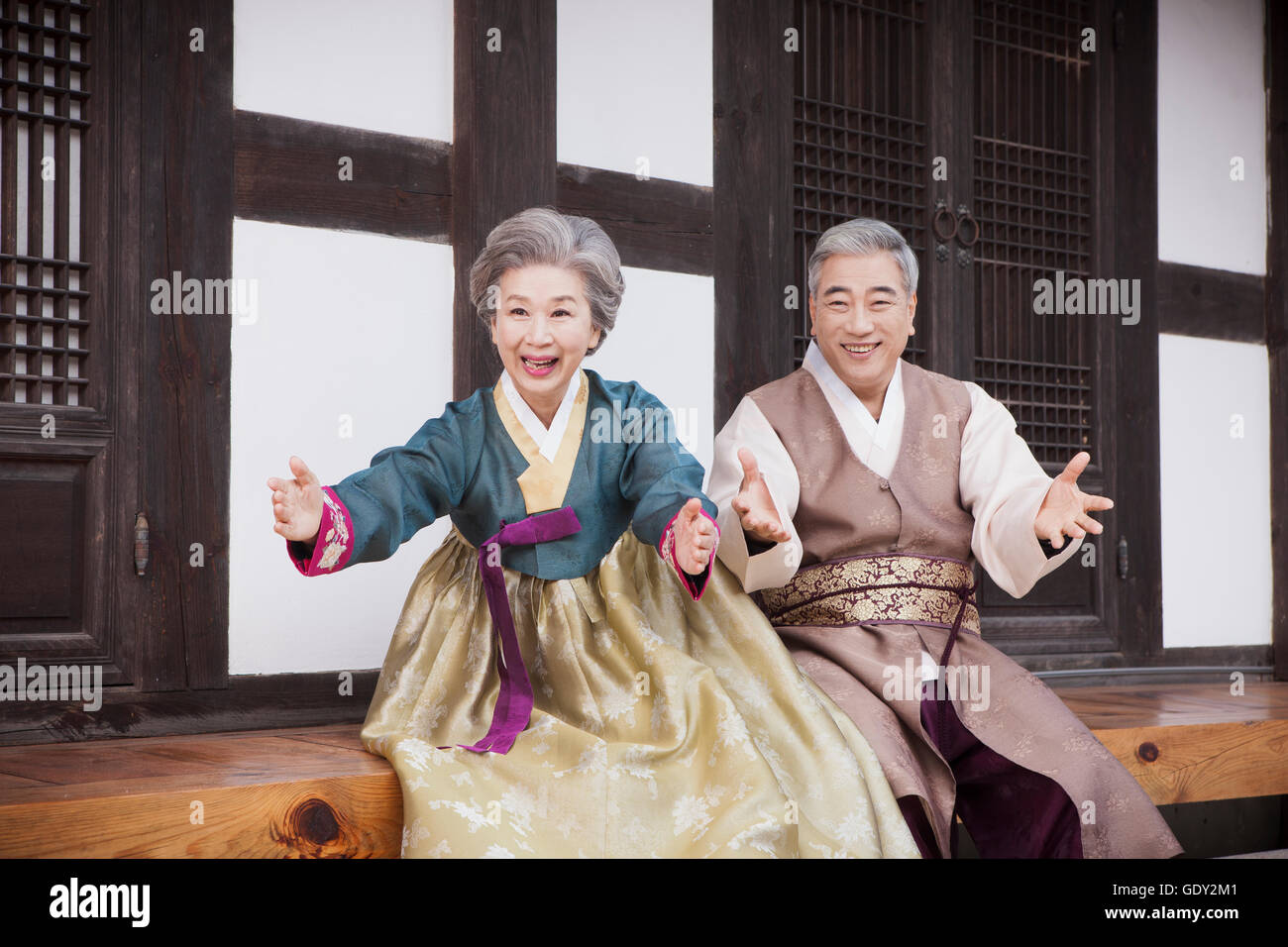 Smiling old Korean couple opening their hands Stock Photo