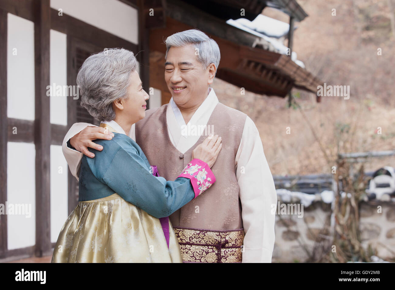 Smiling old Korean couple hugging face to face Stock Photo