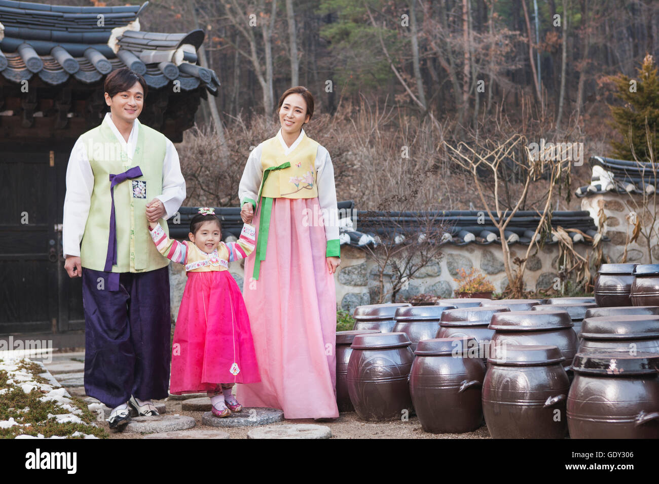 Harmonious family in traditional Korean clothes walking hand in hand in