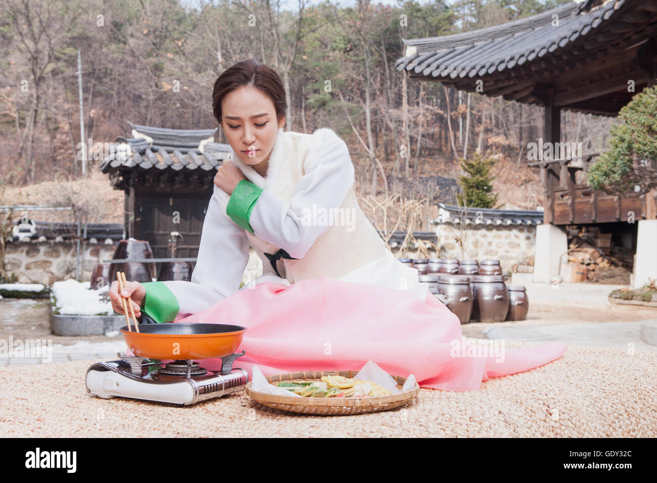 Tired Korean woman cooking traditional Korean holiday food Stock Photo