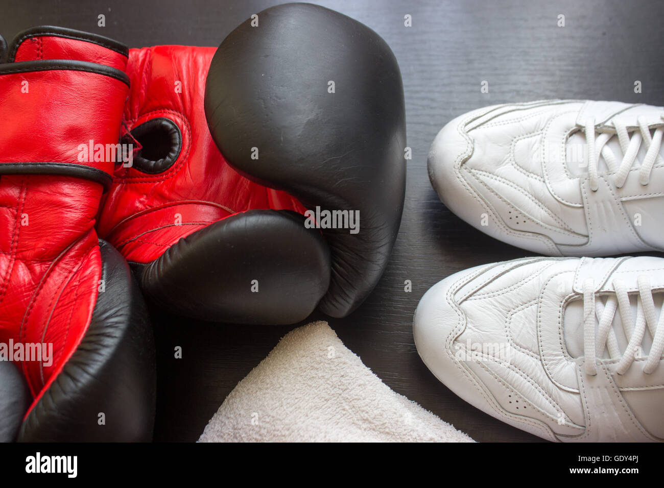 Boxing shoes, gloves and towel on black 