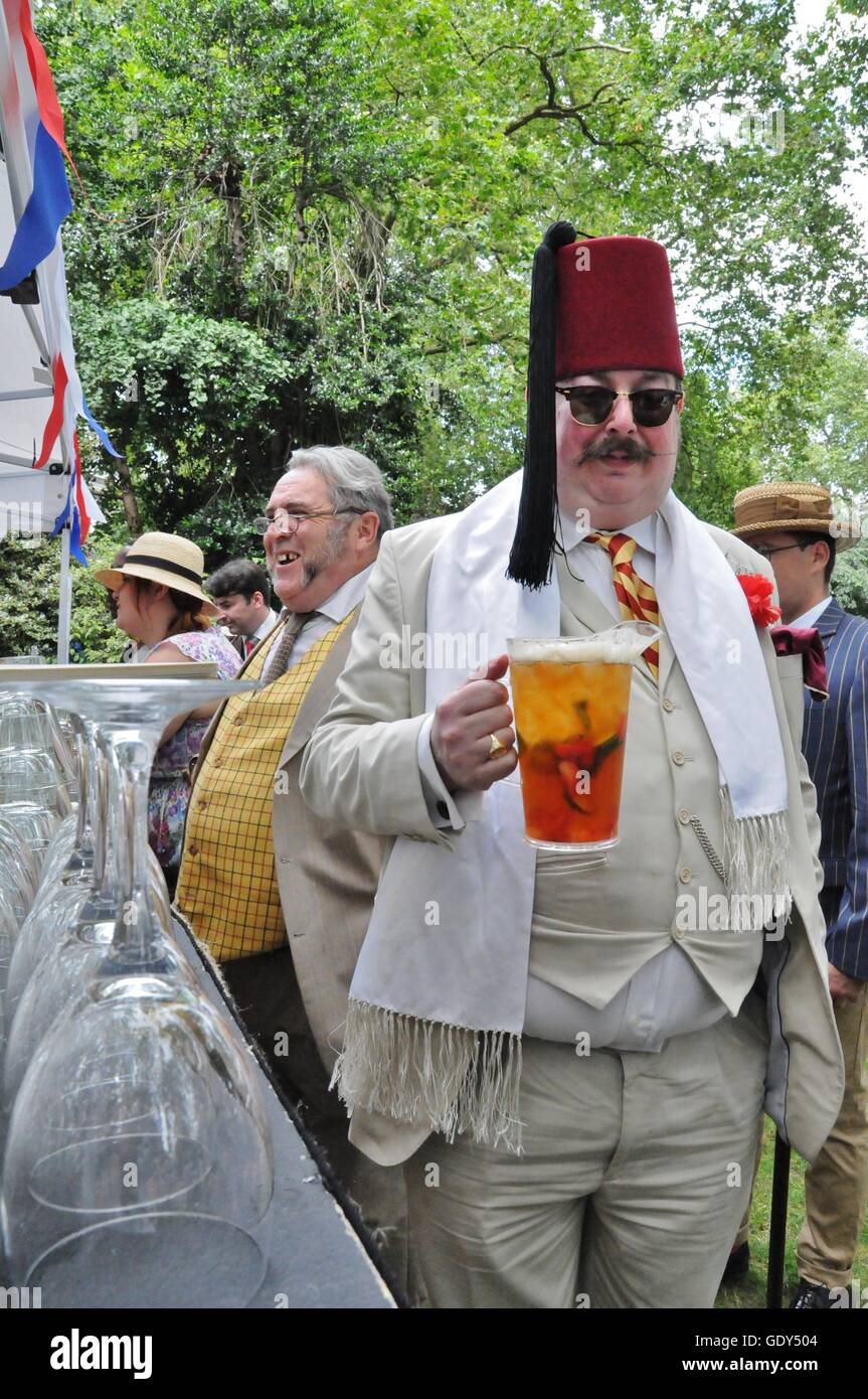 Large man wearing a fez, with a jug of Pimms, at the 2016 Chap Olympiad in London's Bedford Square. Stock Photo