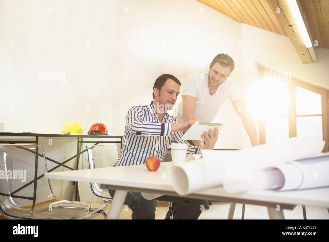 Architects discussing about project on digital tablet in office, Bavaria, Germany Stock Photo