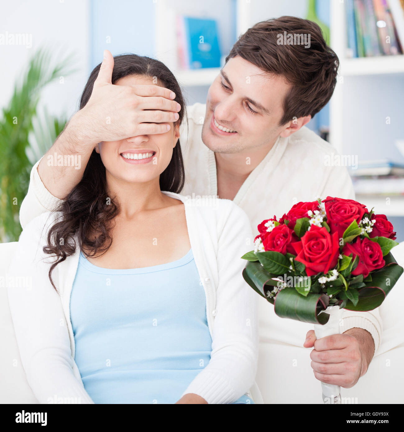 Close up portrait of a young loving couple with a bouquet of red roses ...