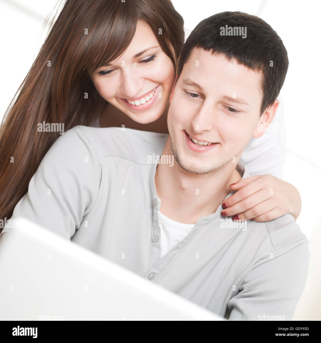 Portrait of a happy couple using laptop in the living room Stock Photo ...