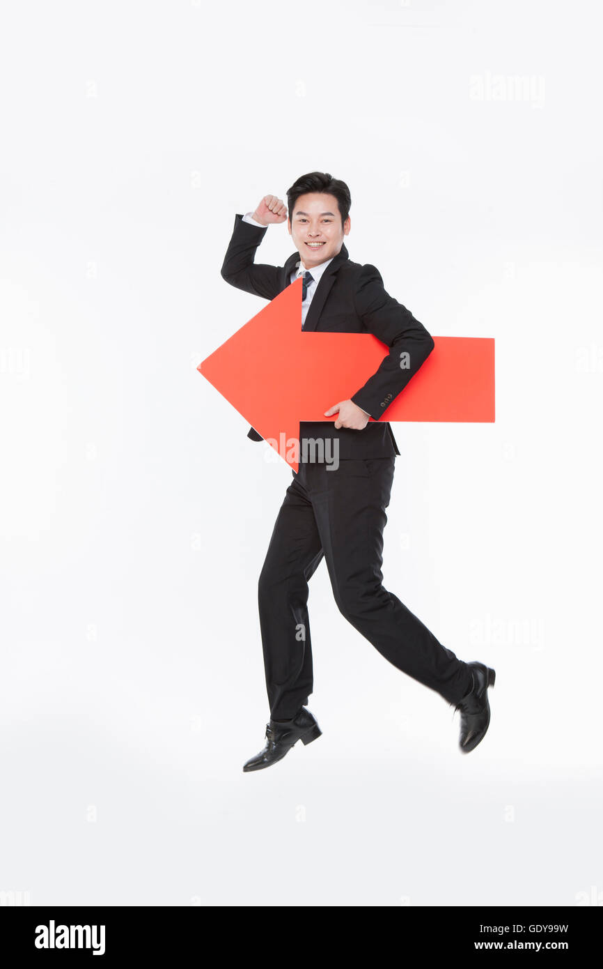 Smiling business man in suit holding a red arrow Stock Photo - Alamy