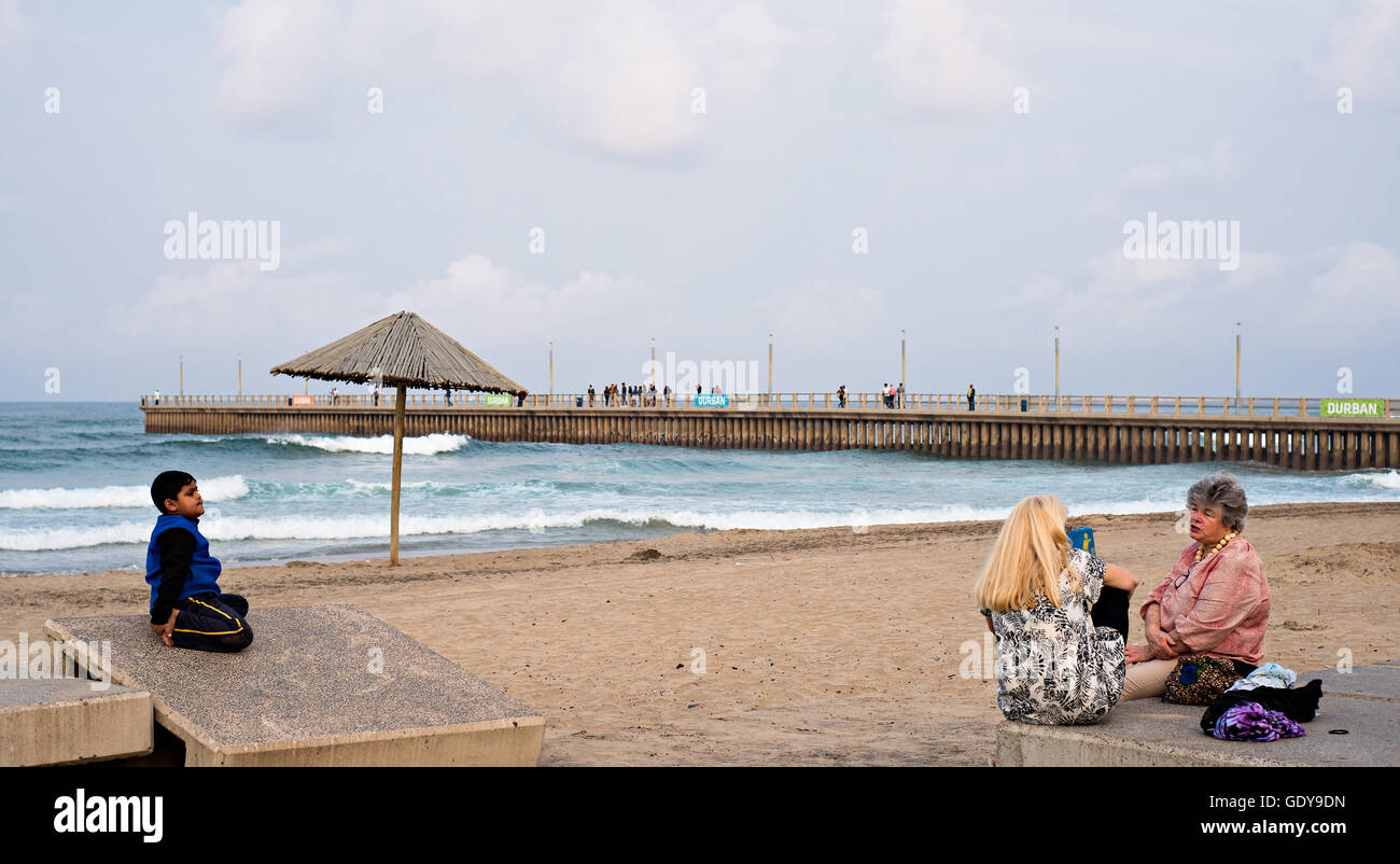 DURBAN, SOUTH AFRICA - AUGUST 17, 2015: People sitting near the pier at North Beach on the Golden Mile promenade. Stock Photo