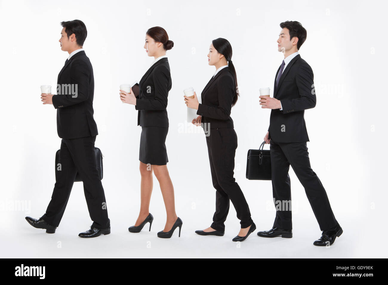 Side view of four business people walking lining up Stock Photo Alamy