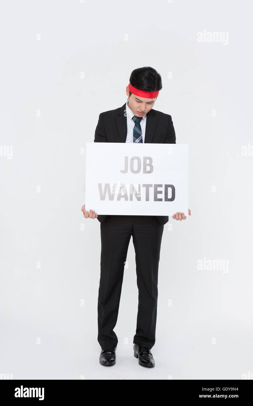 One male business protester standing with message of JOB WANTED looking down Stock Photo