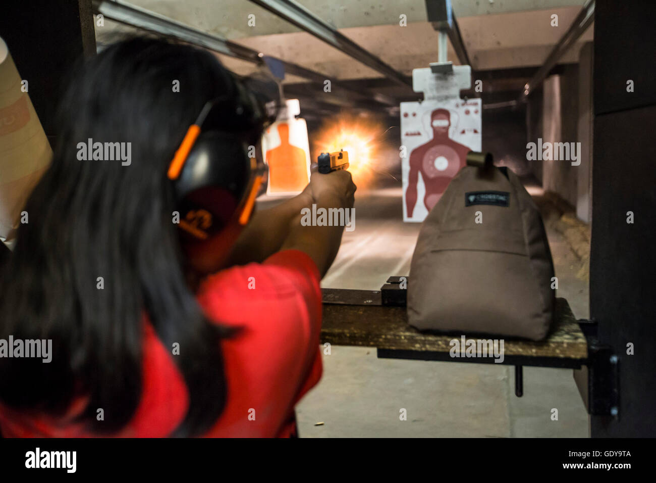 Las Vegas, Nevada - A woman fires her handgun at the Discount Firearms + Ammo indoor shooting range. Stock Photo