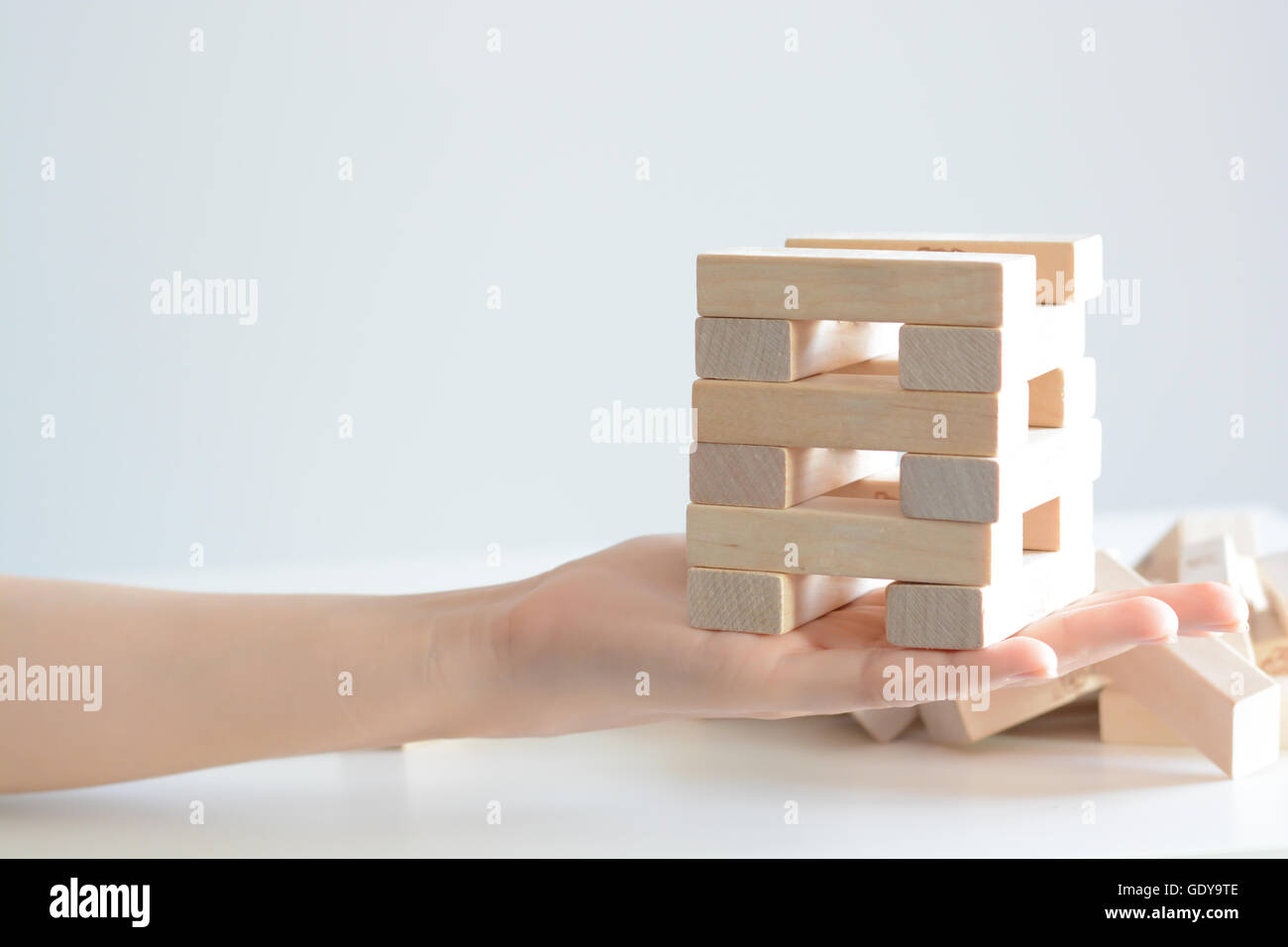 Security or insurance concept with hands protecting construction made from wooden blocks Stock Photo