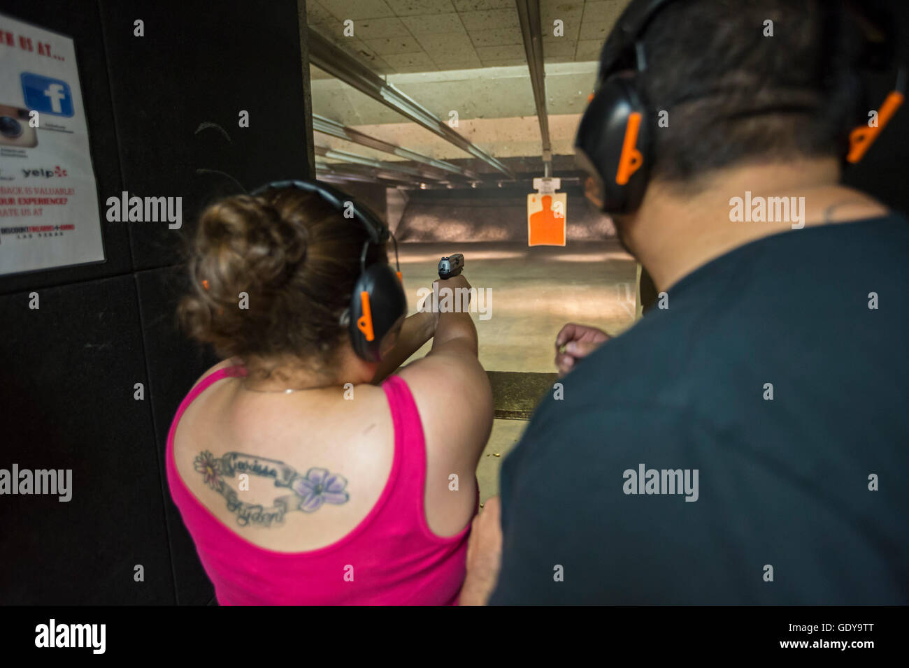 Las Vegas, Nevada - A woman fires her handgun at the Discount Firearms + Ammo indoor shooting range. Stock Photo