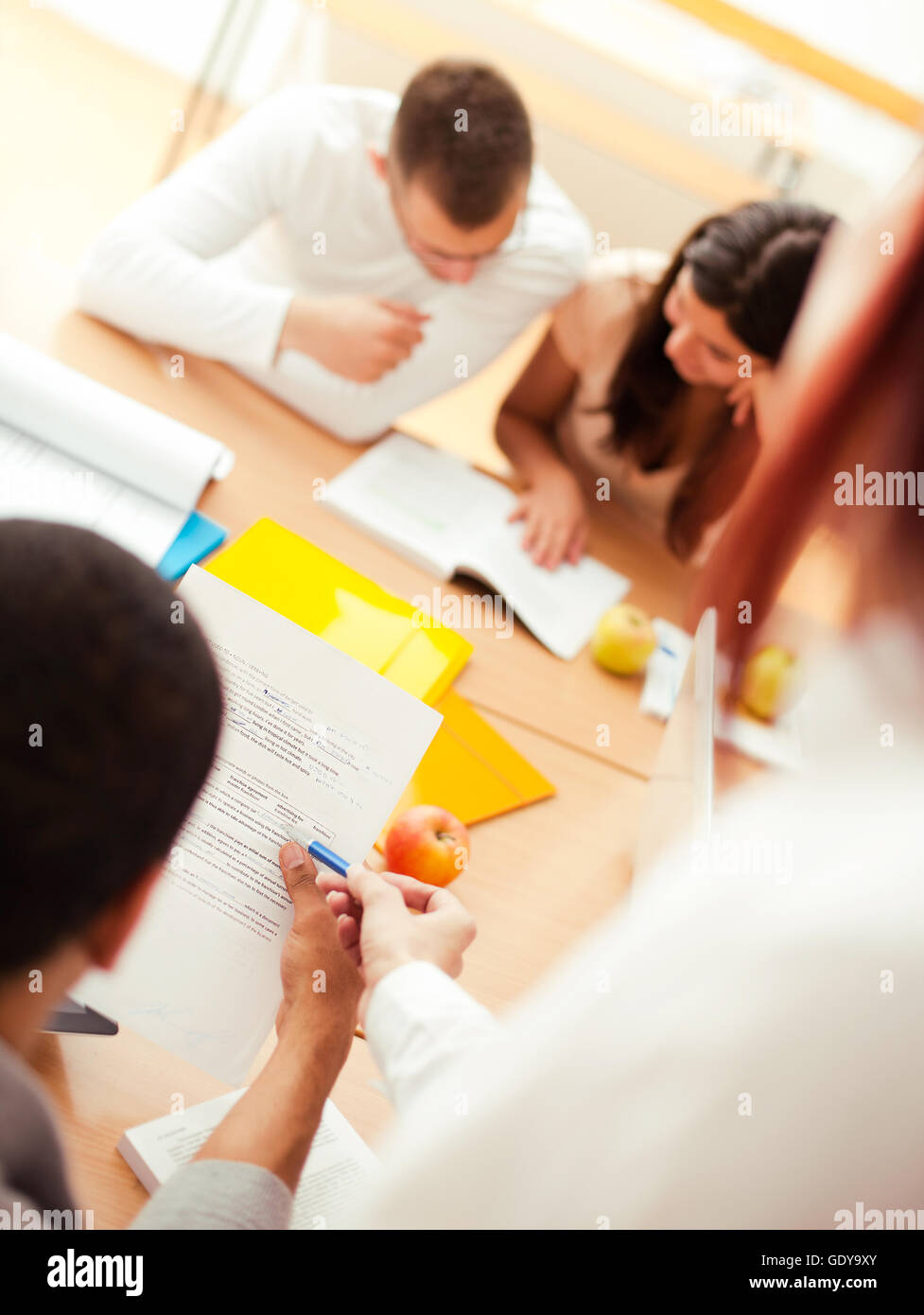 Teacher helping her students while studying. Stock Photo