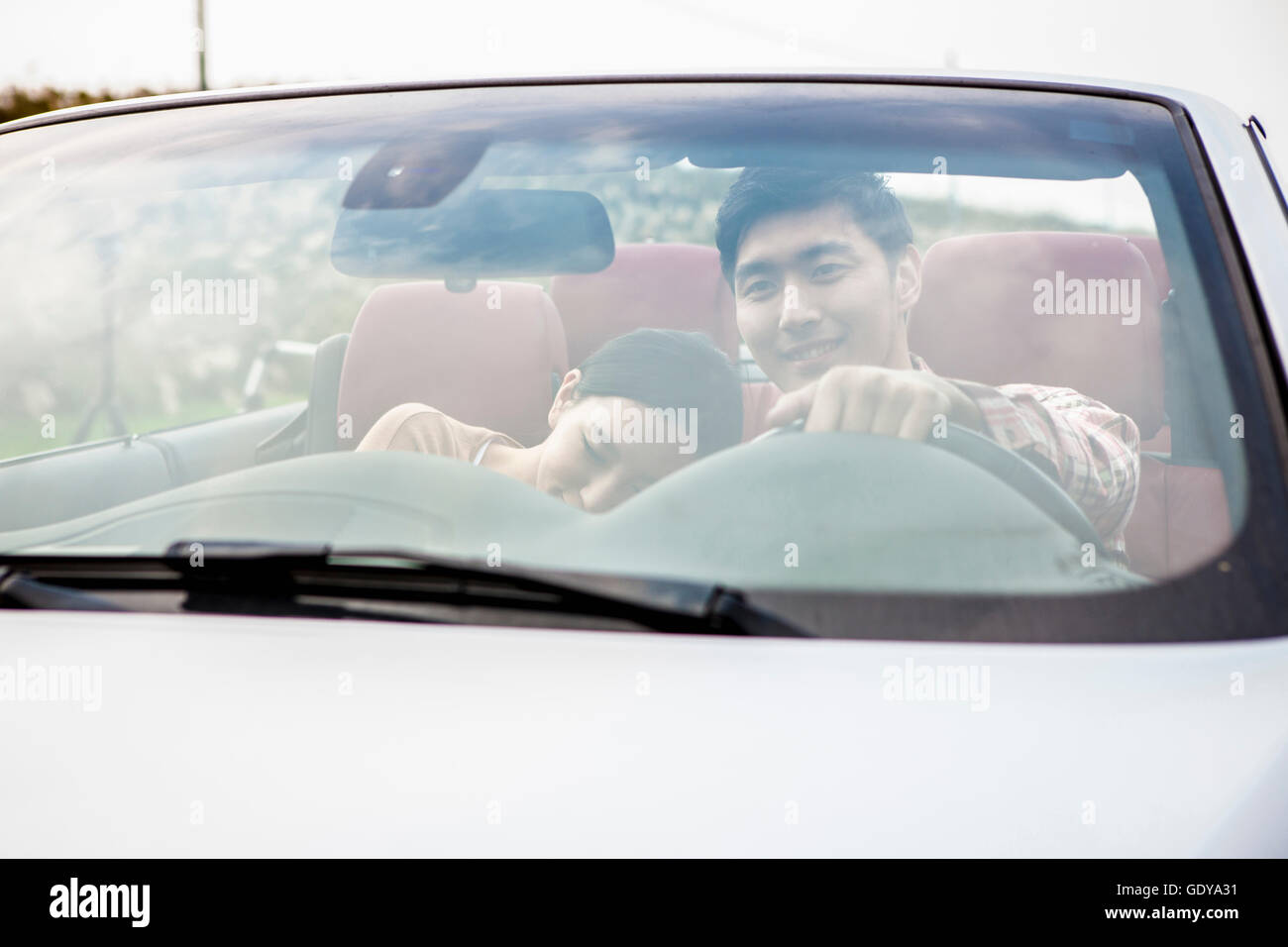 Portrait of young smiling couple in a car Stock Photo
