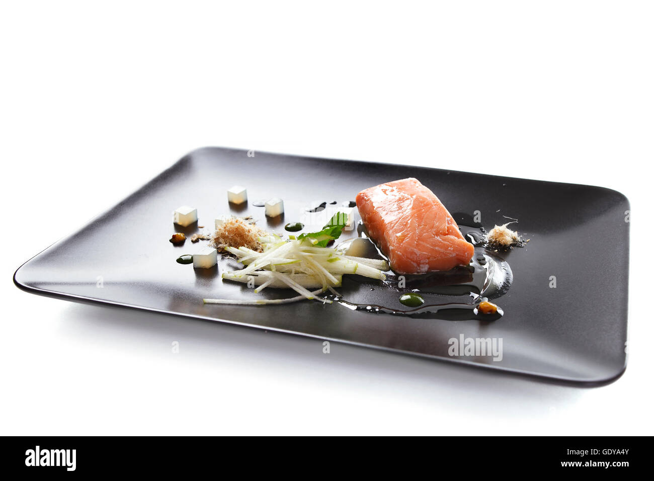 Molecular modern cuisine red fish in a dish with beautiful garnish close up. Isolated Stock Photo