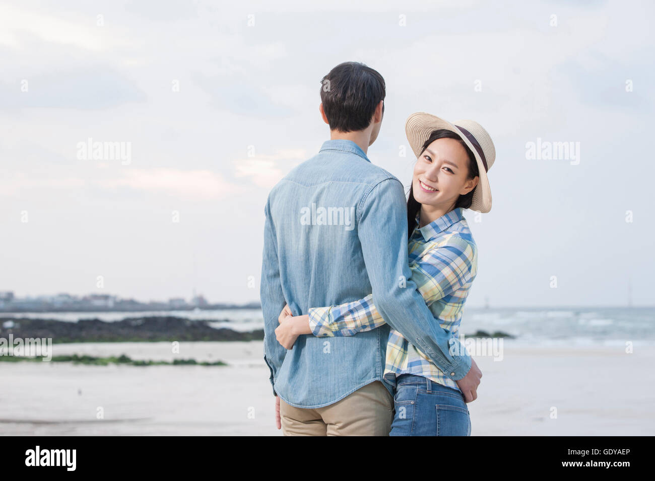 Young smiling woman hugging a man at beach Stock Photo - Alamy