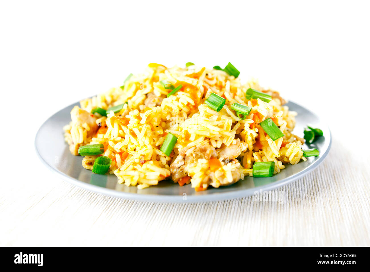 Fragrant Pilau Pulav pilaf pilaf, fried rice with meat and vegetables on a grey plate. Isolated