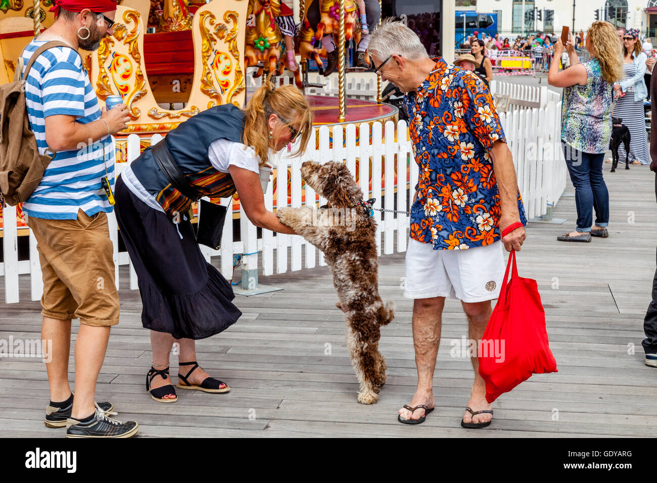 A Woman Stroking A Dog On Hastings Pier, Hastings, Sussex, UK Stock Photo