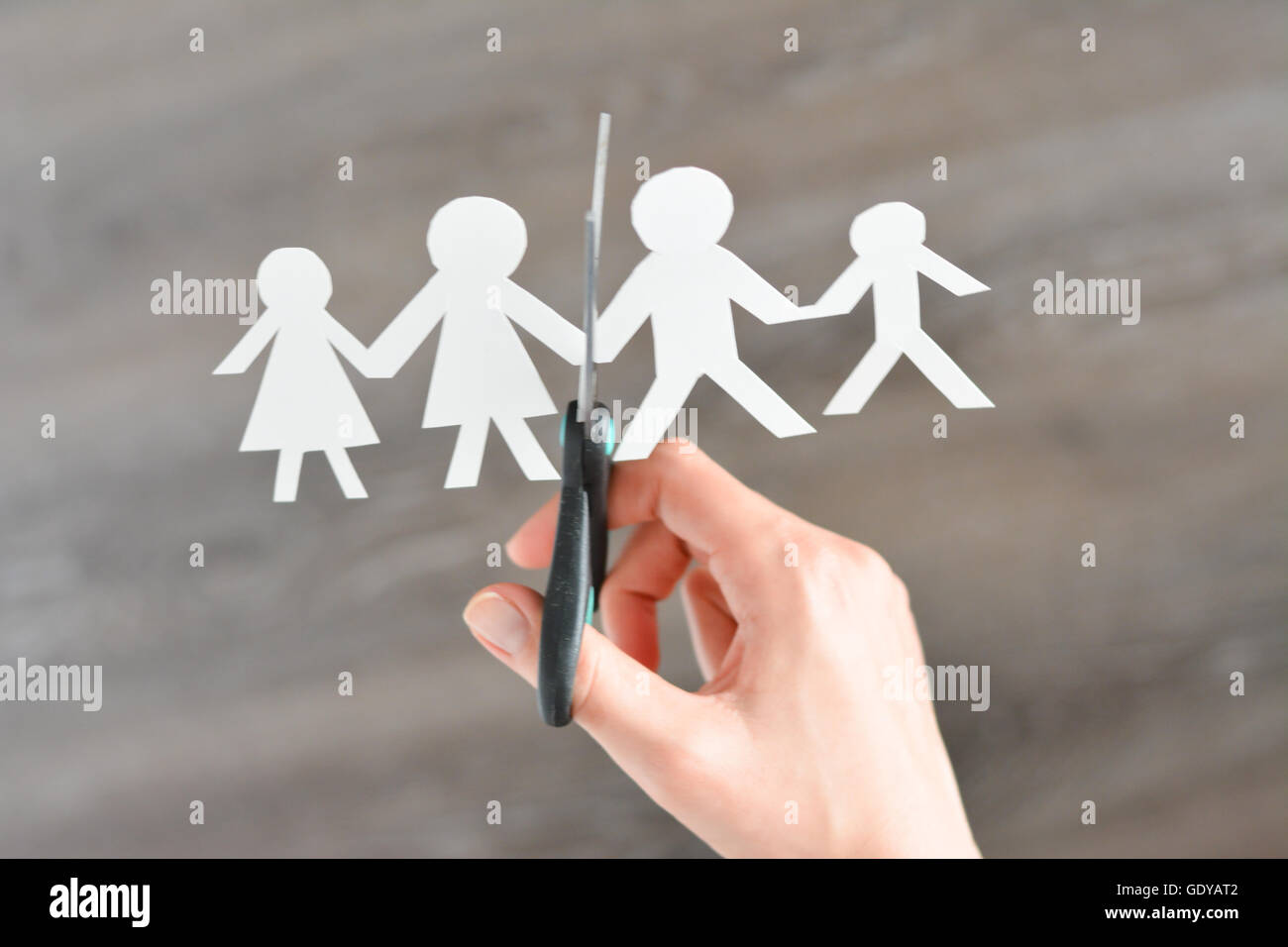 Family divorce concept with human paper shapes and scissors suggesting relationship problems Stock Photo
