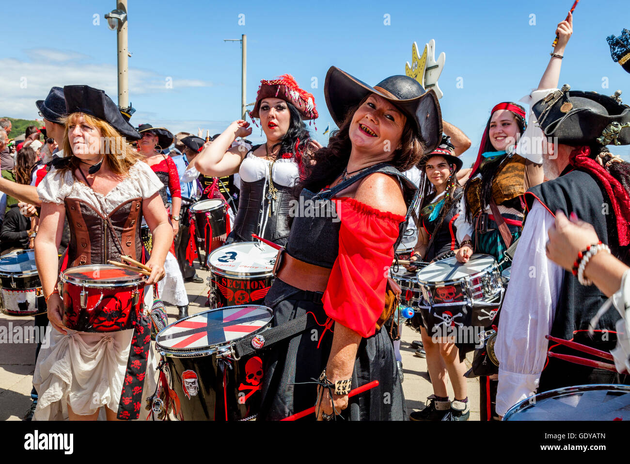 A Group Of Drummers In Pirate Costumes Play On The Seafront During The