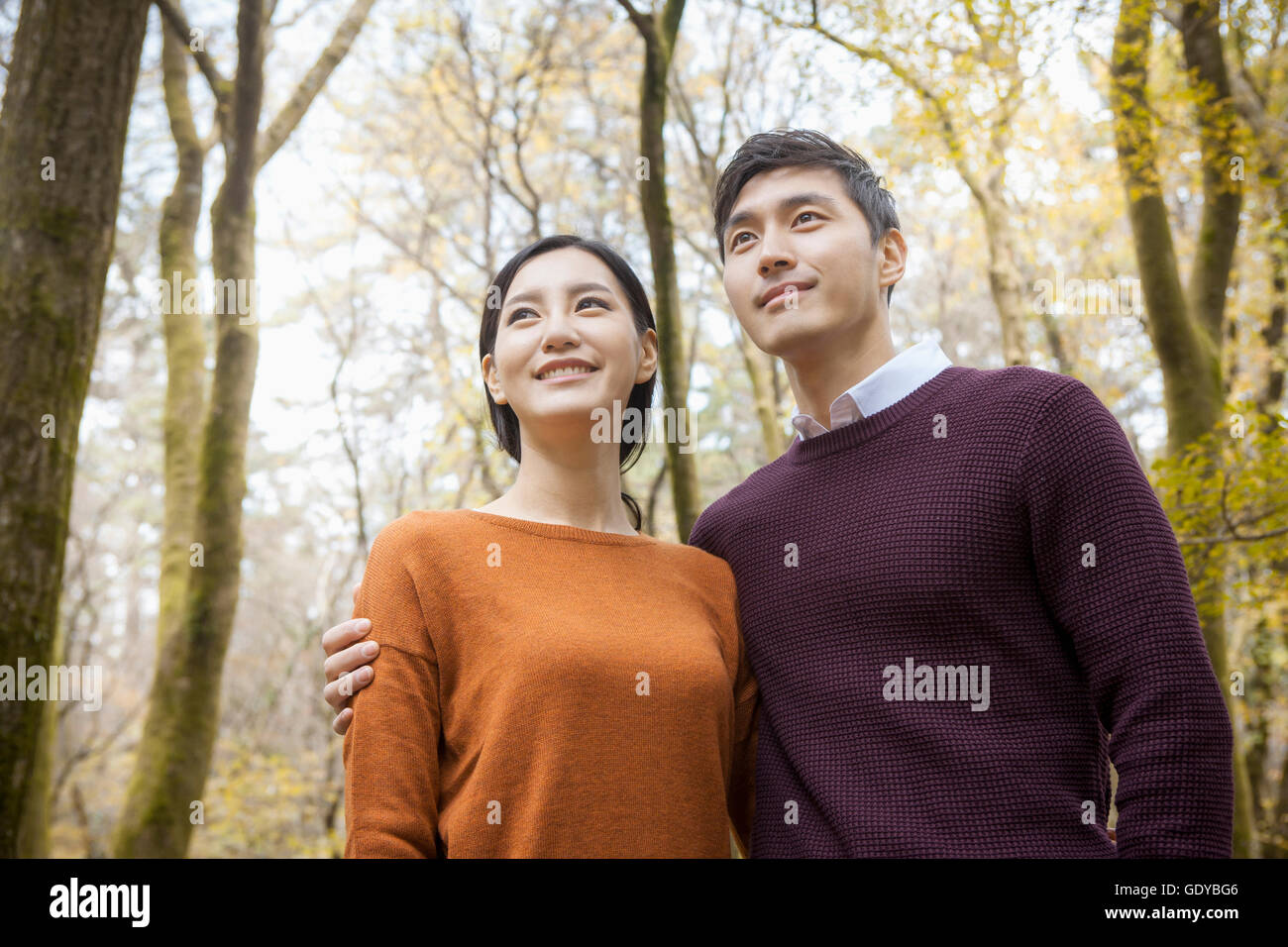 Portrait of young smiling couple in forest in fall Stock Photo - Alamy