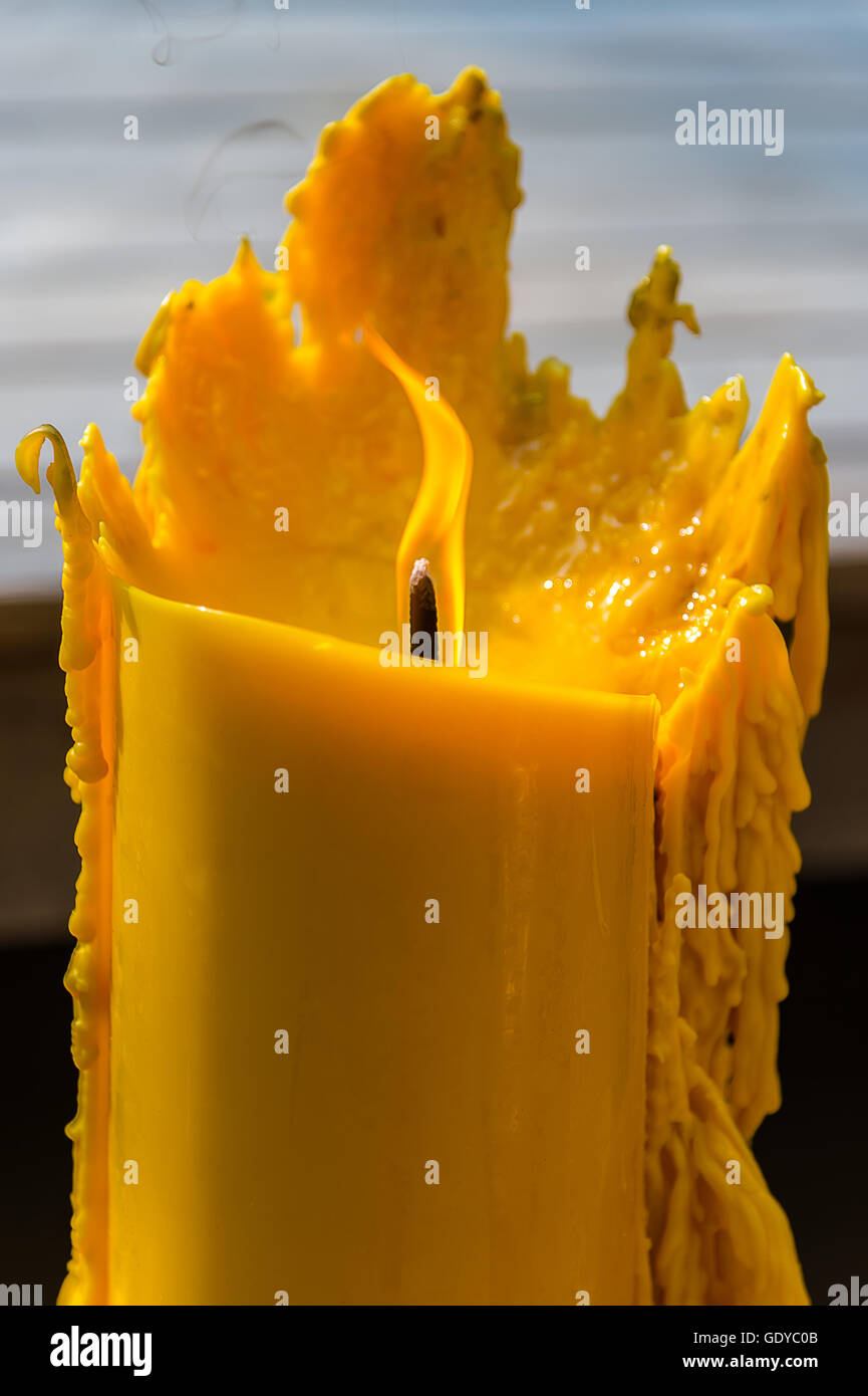 Yellow candle with flame and melting wax Stock Photo Alamy