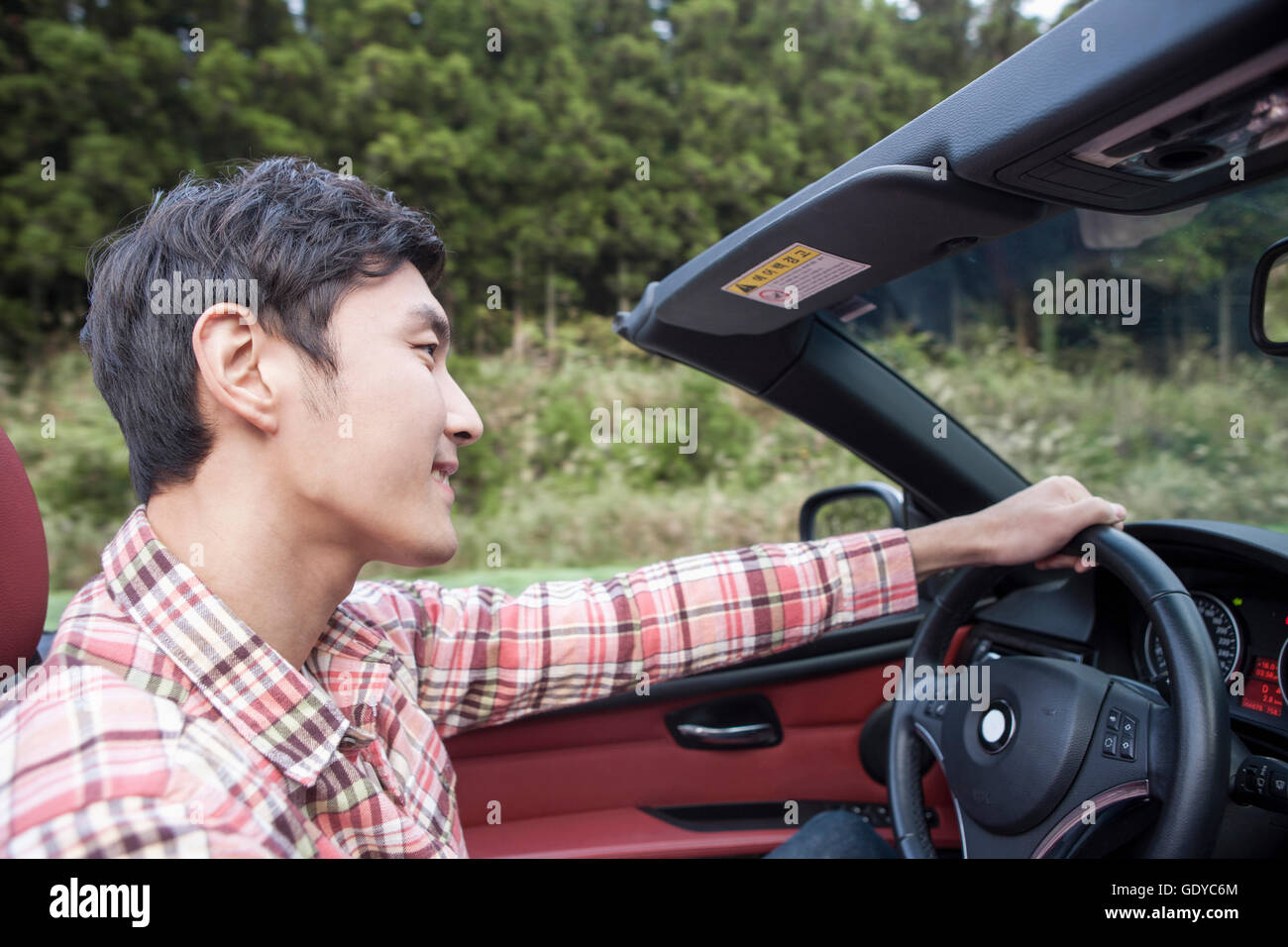 Side view portrait of young man driving a car Stock Photo